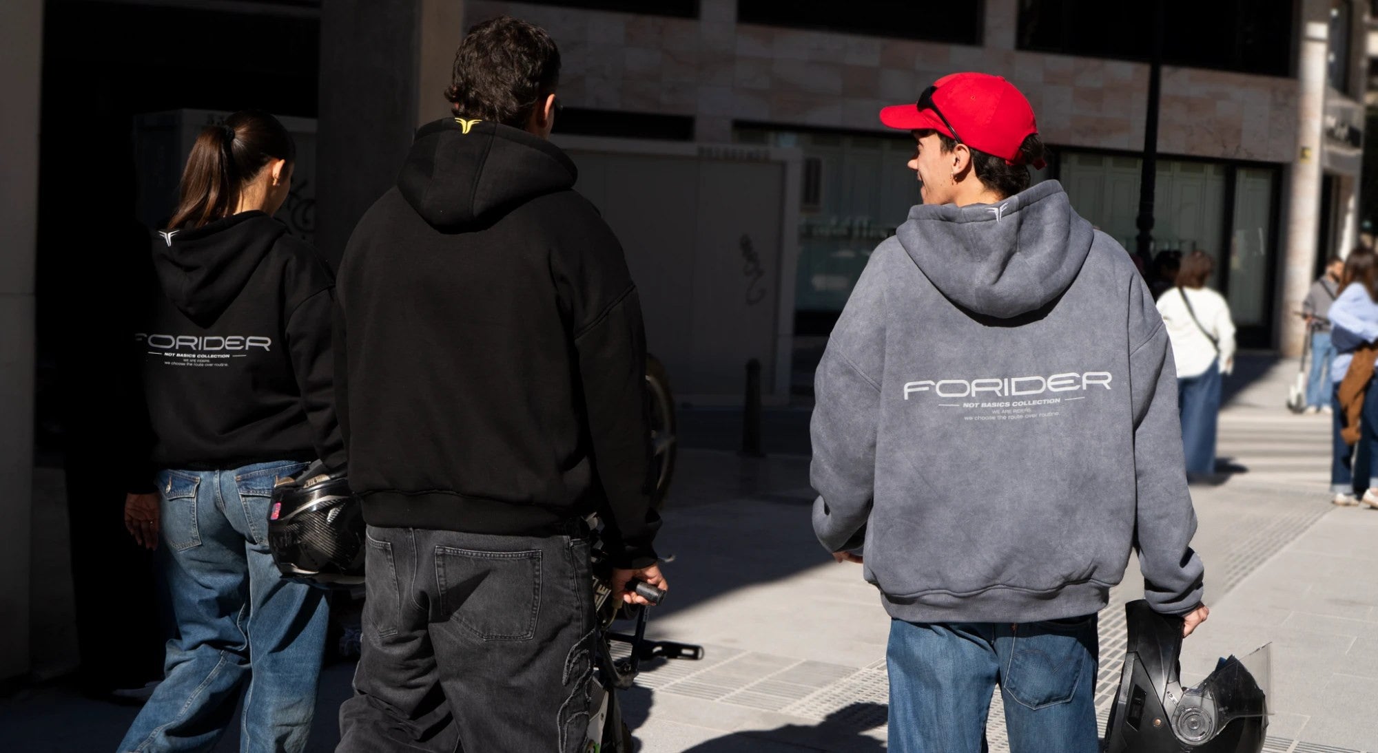 Tres riders con sudaderas FORIDER caminando por la calle