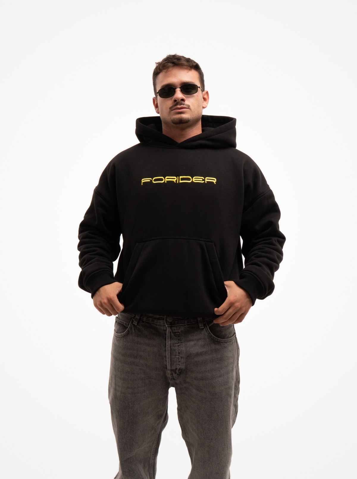 Hombre con la sudadera de moto negra FORIDER vista de frente, con el logotipo amarillo en el pecho y vaqueros grises