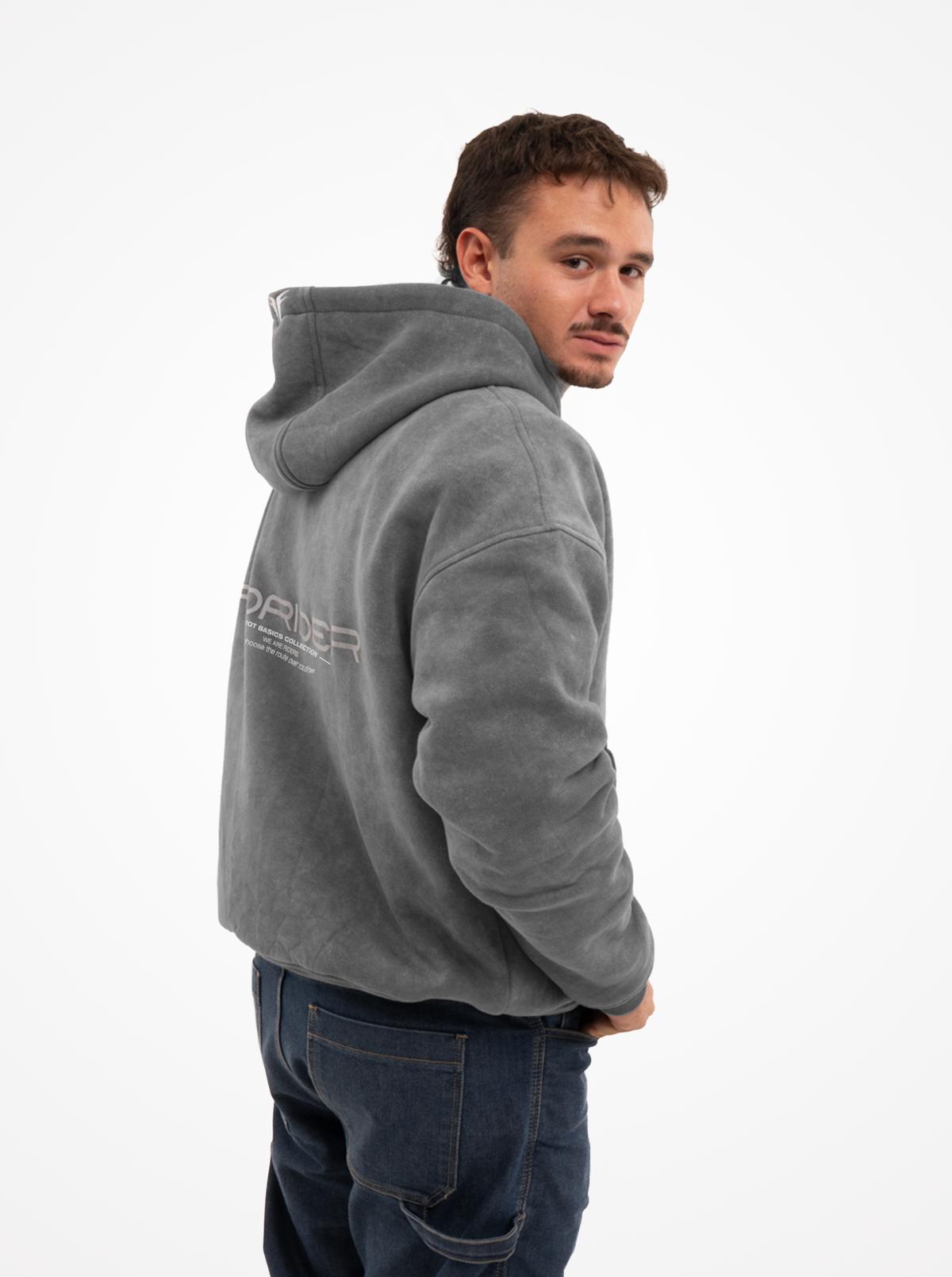 Hombre con la sudadera de moto gris washed mirando por encima del hombro, con el estampado FORIDER en la espalda