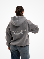 Mujer de espaldas con la sudadera de moto gris washed, capucha con logotipo y estampado FORIDER Not Basics Collection