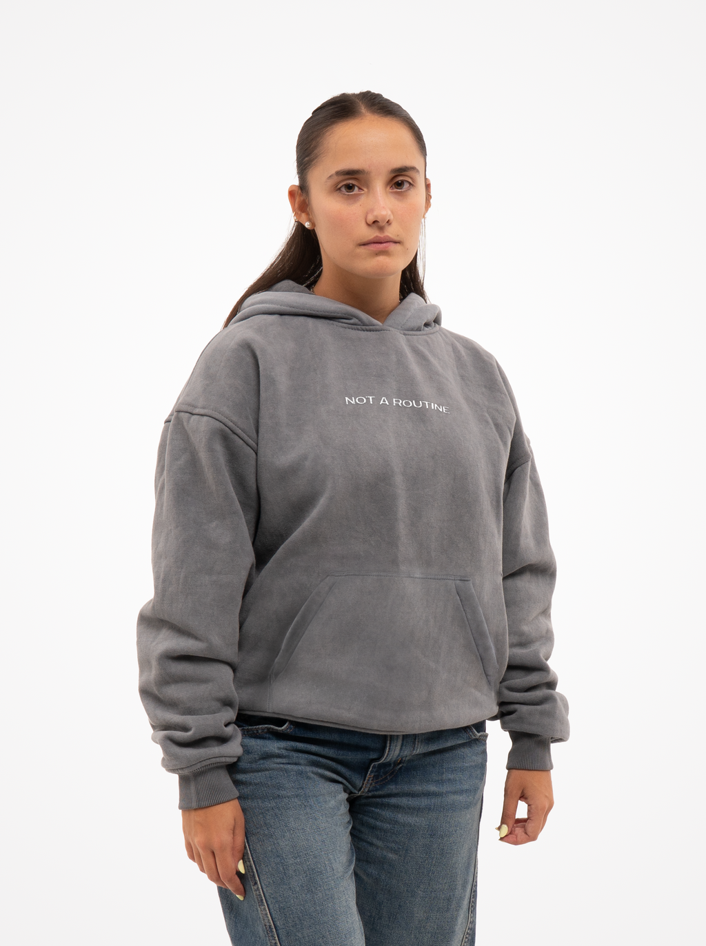 Mujer con la sudadera de moto gris washed Not a Routine, vista frontal con capucha y vaqueros
