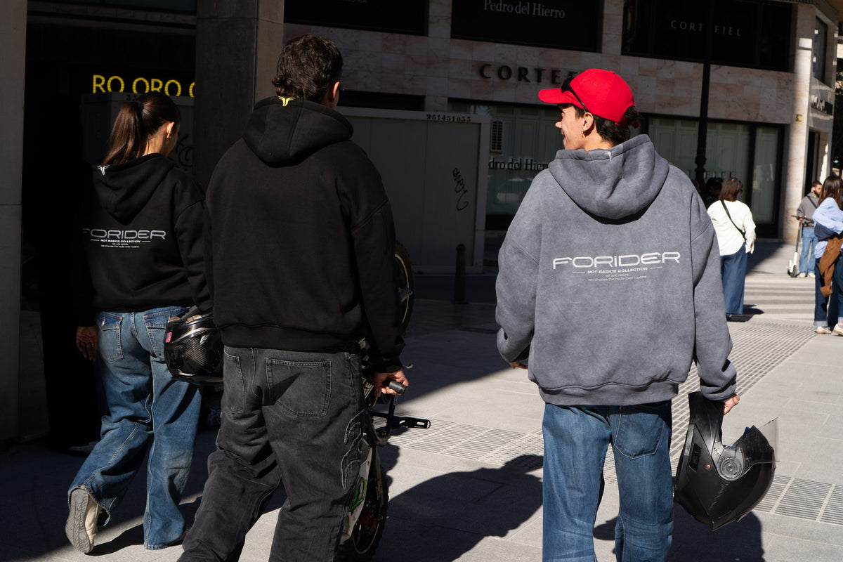 Tres riders caminando por la calle con sudaderas Not Basics